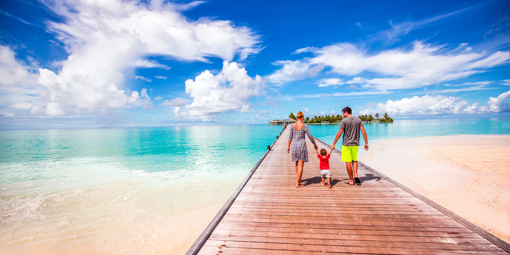 About Me - Photo of a young family walking on a pier on one of the most beautiful Maldivian islands in the Indian Ocean