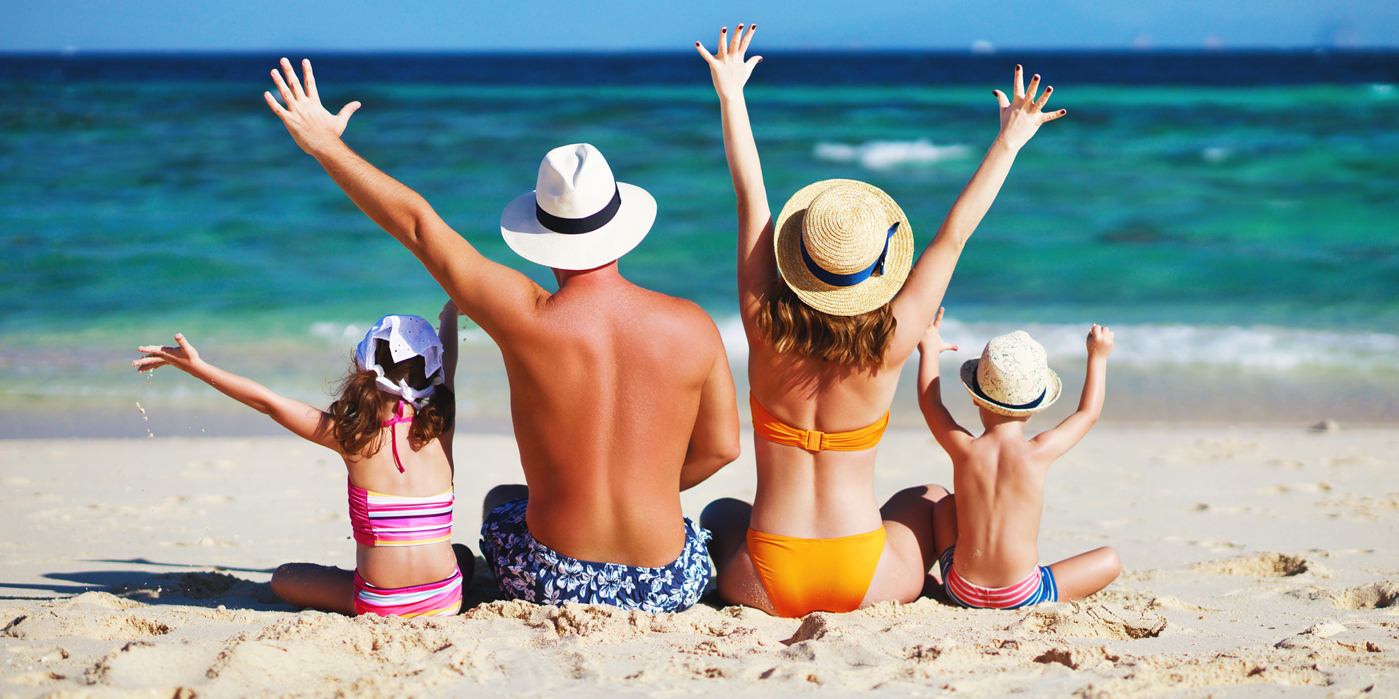 Land Vacations - happy family father, mother and children backs on the beach at sea