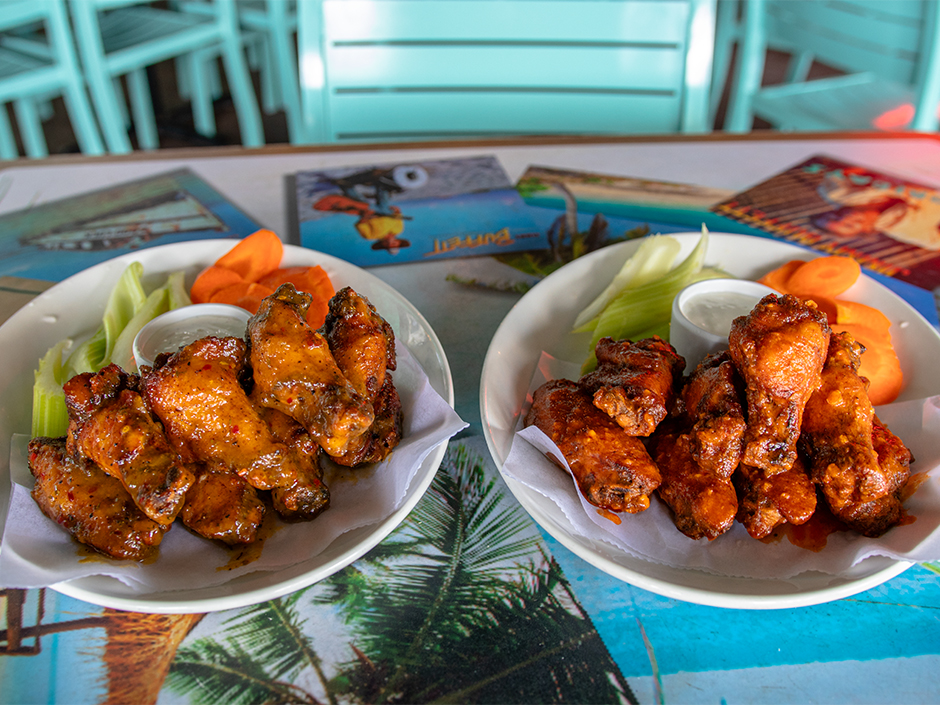 Plates of the bone-in Hemisphere Wings with a side of carrots, celery, and ranch, a dish on the new menu at Jimmy Buffett's Margaritaville in Universal CityWalk.