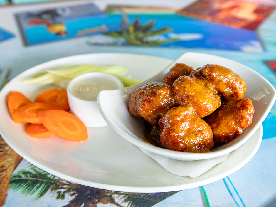 Plate of the boneless spicy mango jerk Hemisphere Wings with a side of celery, carrots, and ranch, a new dish at Jimmy Buffett's Margaritaville in Universal CityWalk.