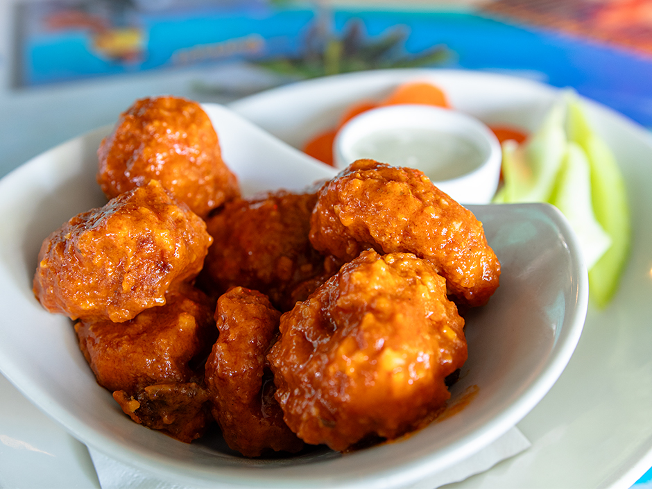 Plate of the boneless tangy garlic buffalo Hemisphere Wings with a side of carrots, celery, and ranch, a new dish at Jimmy Buffett's Margaritaville in Universal CityWalk.