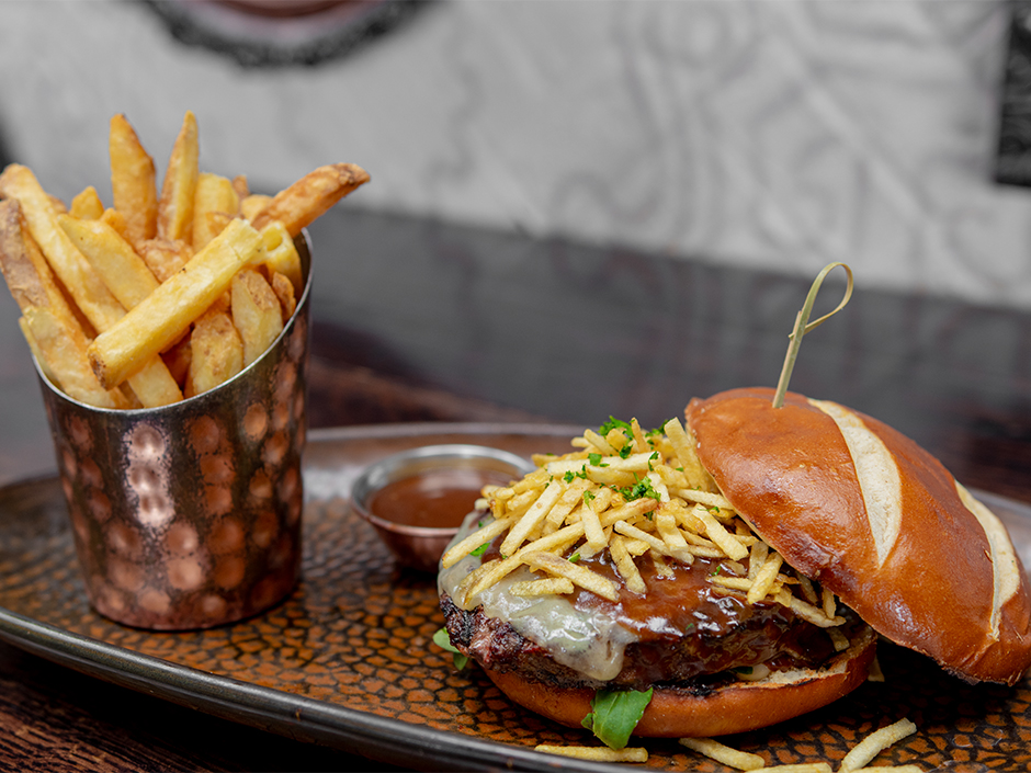 Plate of the Burger Au Poivre with a side of French fries, a new dish at The Toothsome Chocolate Emporium & Savory Feast Kitchen in Universal CityWalk.