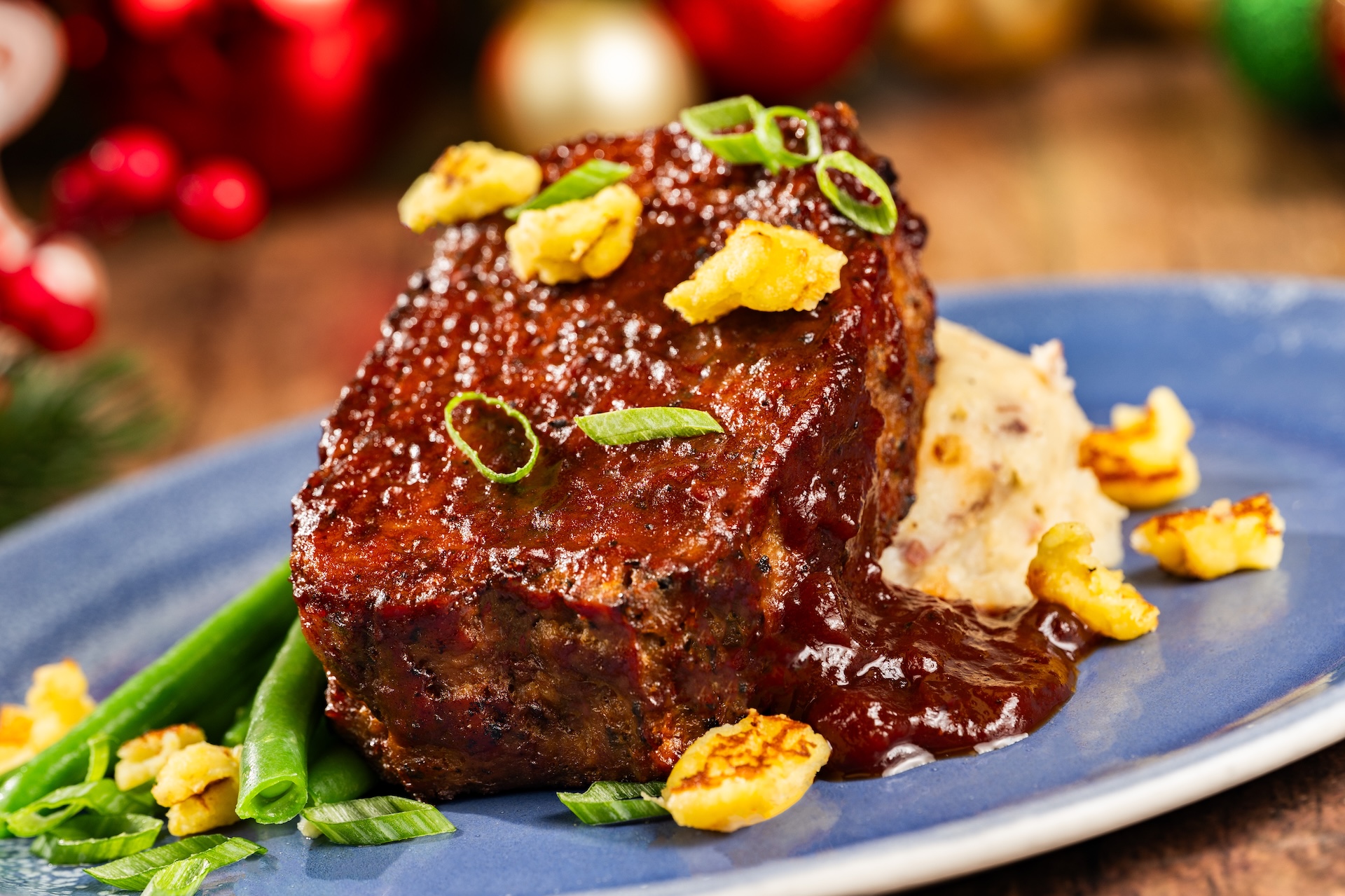 Holiday Turkey Meatloaf with mashed potatoes, green beans, cornbread crumbles, and cranberry barbecue sauce