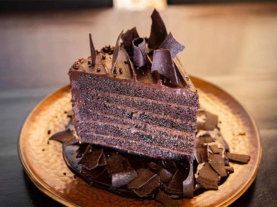 A 7 Layer Chocolate Decadence Cake on a plate at The Toothsome Chocolate Emporium & Savory Feast Kitchen at Universal CityWalk.