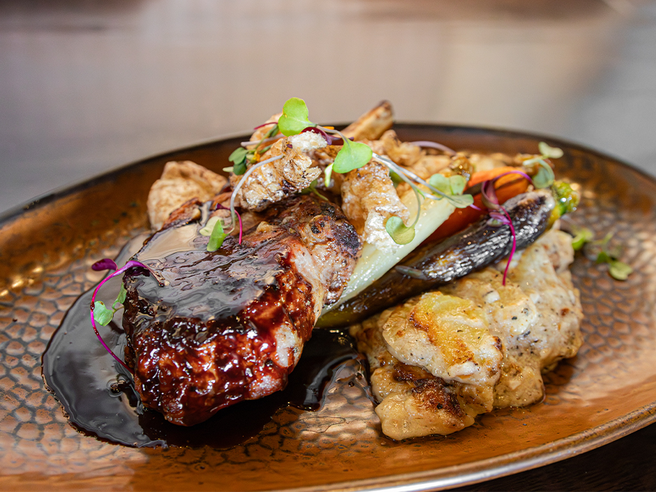 A plate of Chocolate Pomegranate Barbecue Pork Porterhouse for National Chocolate Day at The Toothsome Chocolate Emporium & Savory Feast Kitchen at Universal CityWalk.