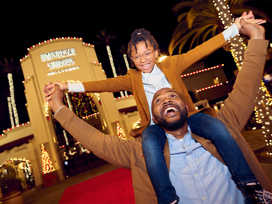 Dad and daughter at the Universal Studios Hollywood arches during the holidays.