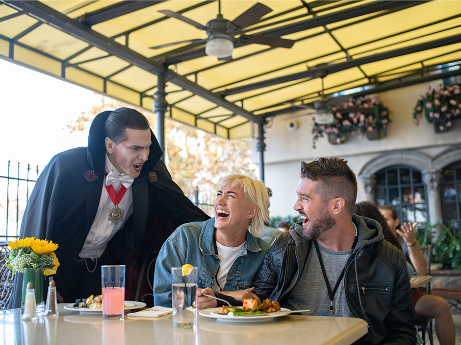 Dracula scares two laughing guests at VIP Dining.