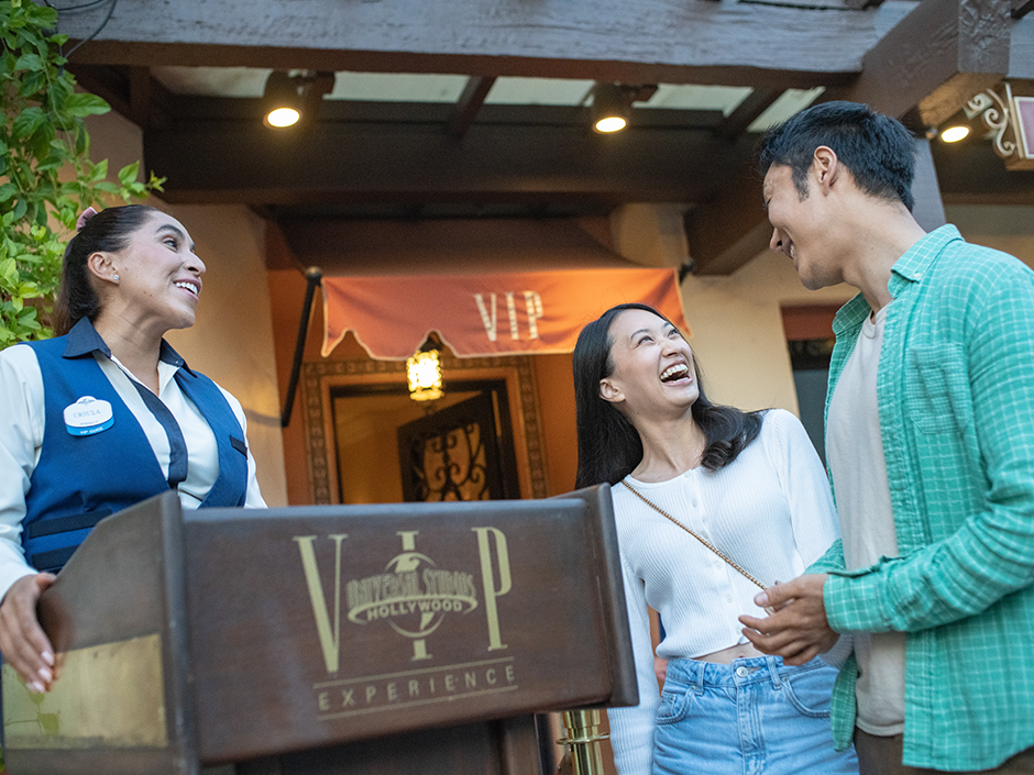 Universal Studios Hollywood VIP tour guide greets two guests at entrance to VIP lobby.
