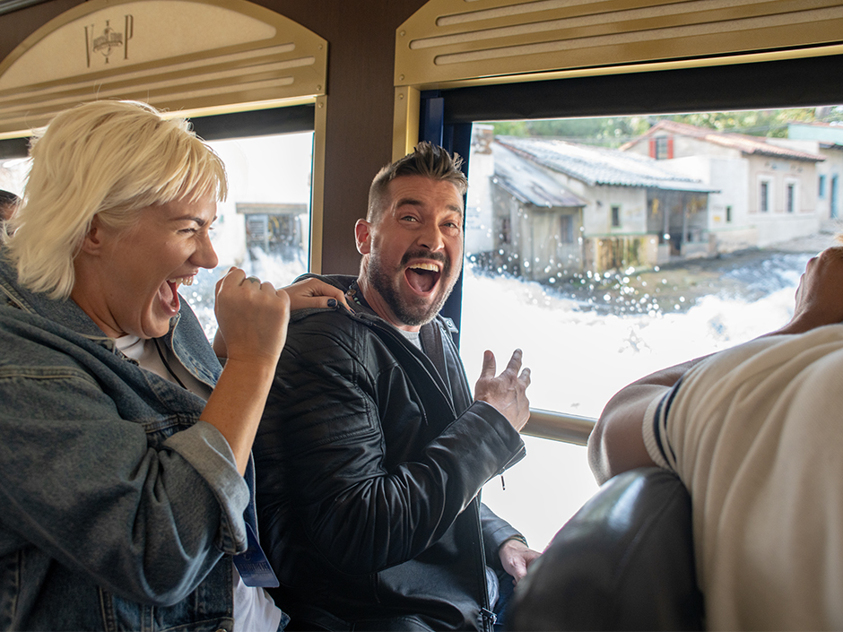Two guests on VIP tour trolley laugh at flash flood on Old Mexico set.