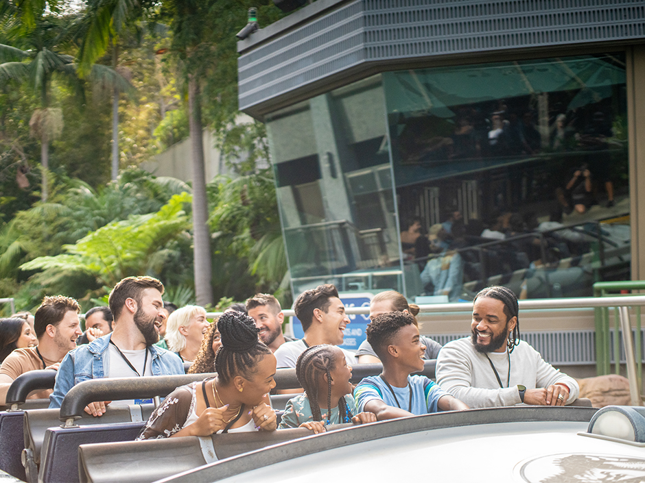 Group of guests smiles on Jurassic World ride.