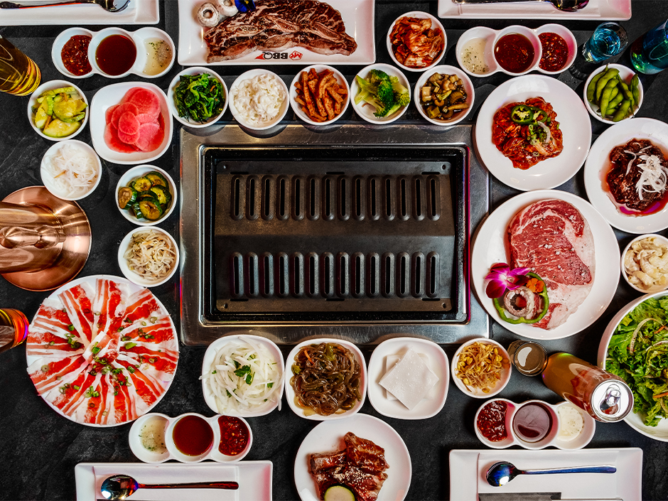 An assortment of Korean dishes around a table grill at Mr. BBQ.