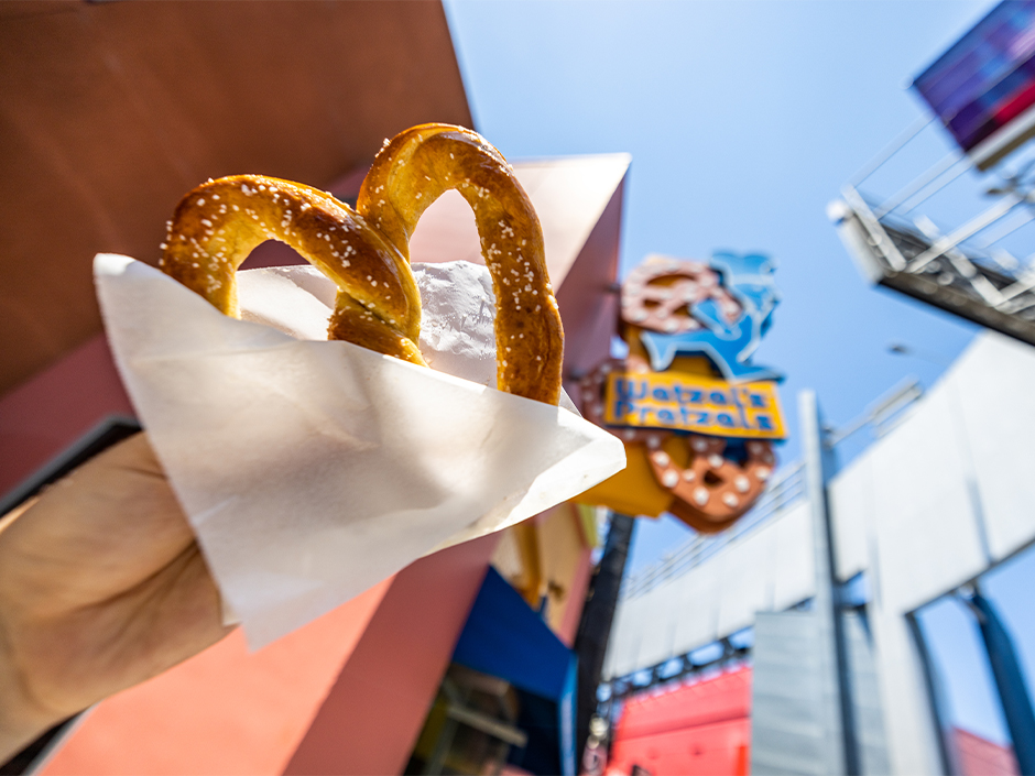 A hand holding up a pretzel.