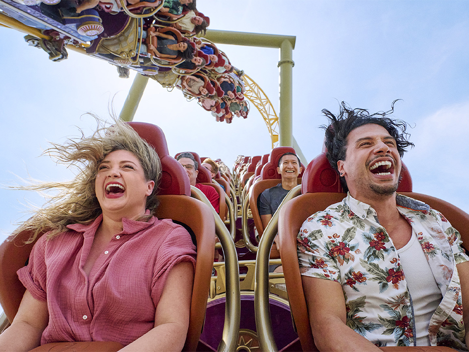 Guests smile as they ride Stardust Racers in Celestial Park