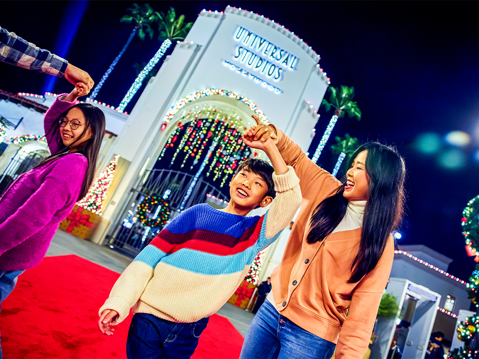 Family outside of Universal Studios Hollywood arch in holiday decor.