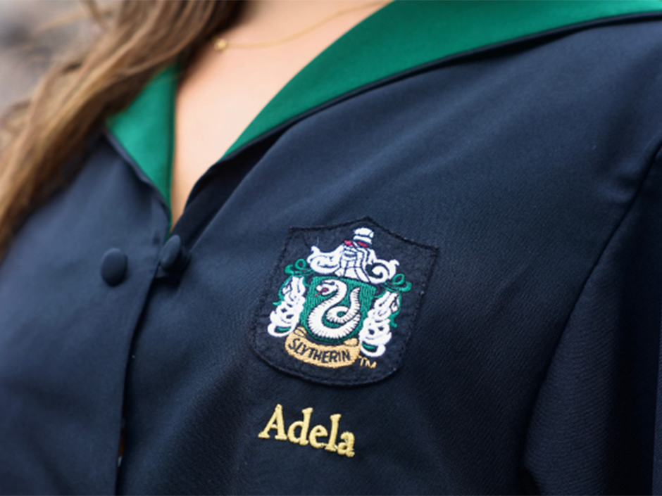 A Slytherin house robe with the name Adela on it.