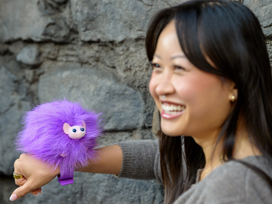 A purple Pygmy Puff attached to a guest's wrist.